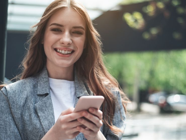 donna esulta con telefono in mano